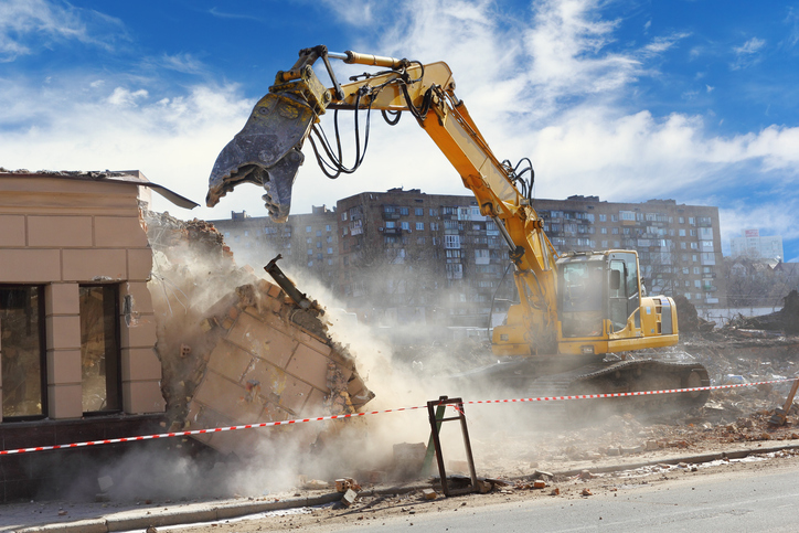 Building demolition releasing dust and debris, representing non-occupational asbestos exposure risk
