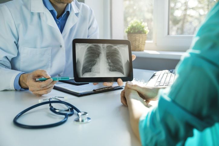 Doctor explaining mesothelioma diagnosis results with lung imaging