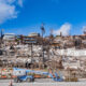 burned home site with protective crews following California wildfire debris cleanup asbestos safety requirements