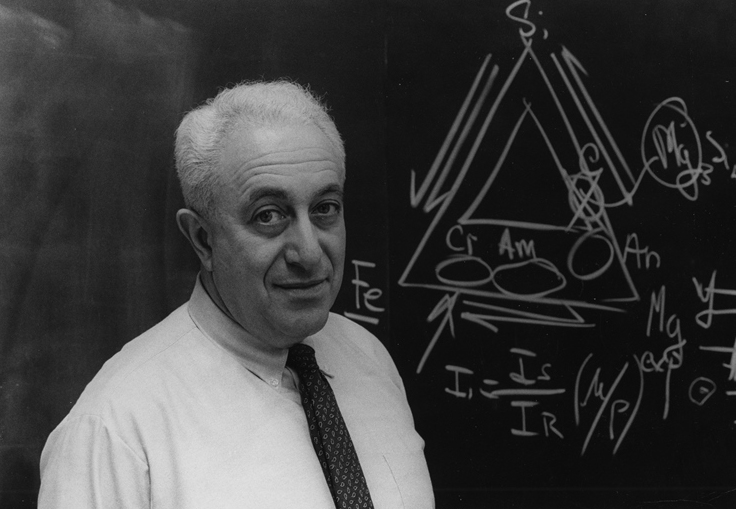 Irving Selikoff standing in front of a blackboard during an asbestos research lecture, symbolizing his leadership in public health and mesothelioma prevention