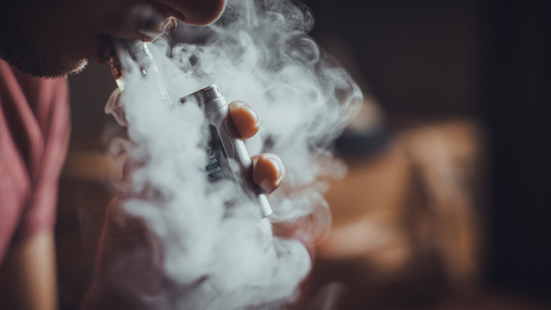 Person vaping with a focus on lungs, representing vaping health risks