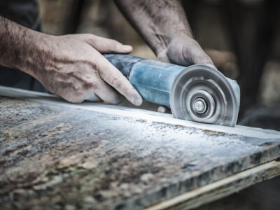 Texas worker cutting engineered stone countertop in dusty environment – engineered stone silicosis Texas