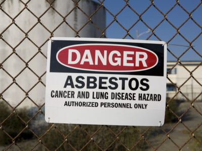 Warning sign reading “Danger Asbestos” highlighting how asbestos exposure causes cancer and lung disease risks.