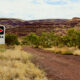 Danger asbestos warning sign at an outdoor mine site with rocky landscape in the background