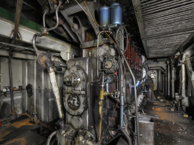 Vintage ship engine room with dense piping, valves, and machinery where asbestos insulation was widely used