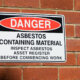 Danger asbestos containing material warning sign mounted on a brick wall