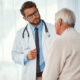 Doctor explaining mesothelioma causes and treatment options to an older patient during a consultation